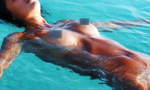 a man swimming in the water in the water at Villa Paraiso - Naturism Optional Adults Only in Porches