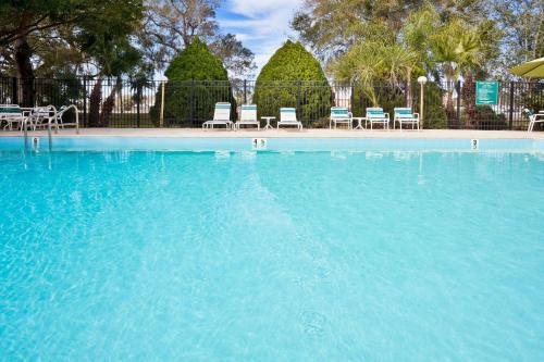 una gran piscina azul con sillas y árboles en La Quinta by Wyndham Tampa Fairgrounds - Casino, en Tampa