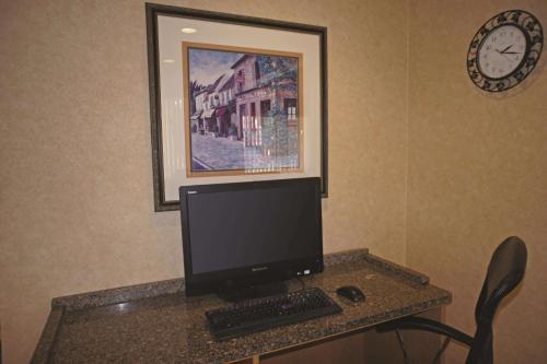 a desk with a computer monitor and a keyboard at La Quinta by Wyndham Tampa Fairgrounds - Casino in Tampa