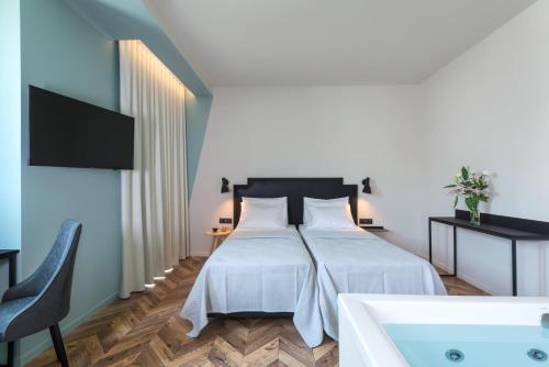 Schlafzimmer mit einem Bett und einer Badewanne in der Unterkunft Athens One Smart Hotel in Athen