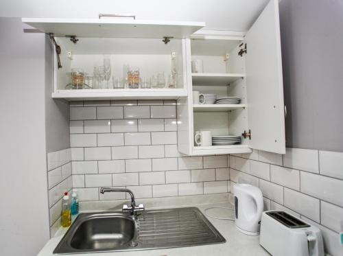 a kitchen with white cabinets and a sink at No 4 New Inn Apartments in Newark upon Trent