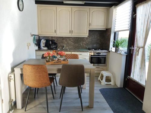 eine Küche mit einem Tisch und Stühlen im Zimmer in der Unterkunft Klepperstee Esdoorn 3 in Ouddorp