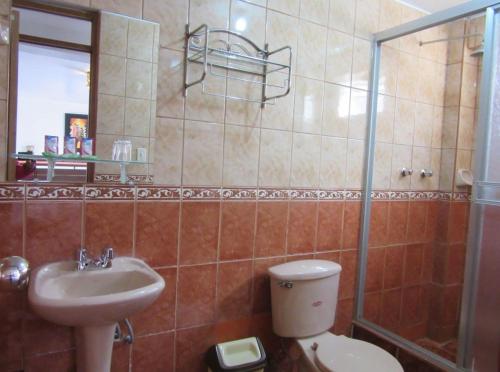 y baño con aseo y lavamanos. en Pukara House, en Puno