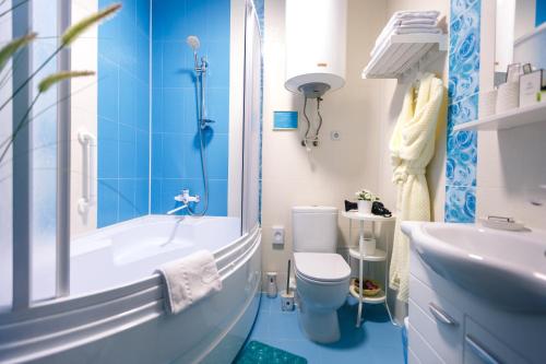 a bathroom with a tub and a toilet and a sink at Abazhur Hotel in Tomsk