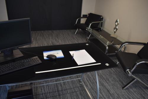 a desk with a computer and a keyboard and mouse at Athens One Smart Hotel in Athens