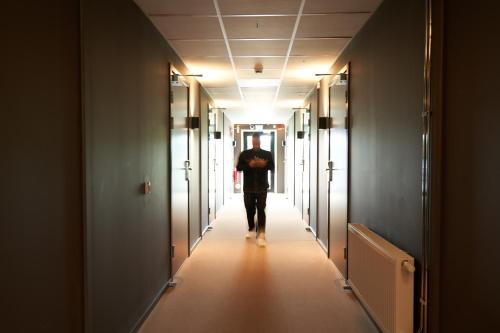 a man walking down a corridor in a hallway at Ekebyhov Hotell in Ekerö
