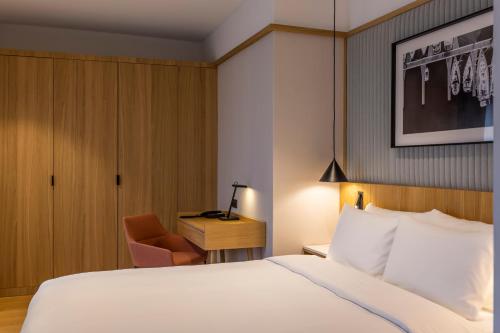 a hotel room with a bed and a chair at Radisson Hotel & Apartments Gdansk in Gdańsk