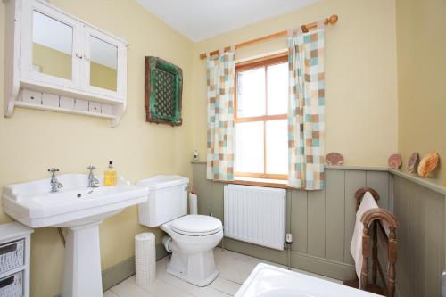 a bathroom with a sink and a toilet and a window at Lovely Country House On The West Coast Of Ireland! in Mullagh