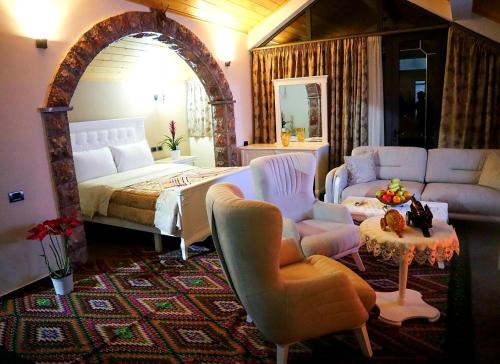 - une chambre avec un lit, un canapé et une table dans l'établissement Villa Parku Rinia, à Korçë