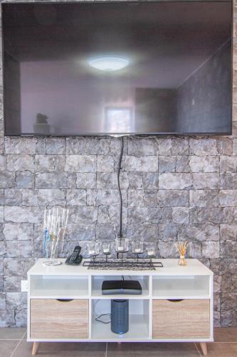 a kitchen with a white counter and a stone wall at Flowers Island house 2 in Funchal