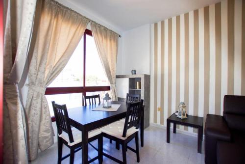 モロ・デル・ハブレにあるVIP HOLIDAYS Morro Jable Beach & Center 2のテーブルと椅子と窓のあるダイニングルーム