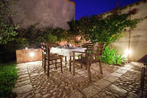 a table and chairs in a garden at night at Palazzo Gambuzza in Ispica
