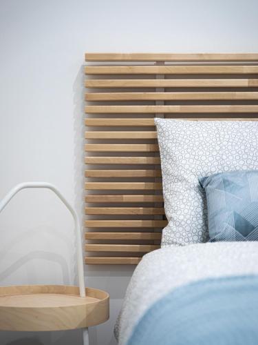 a bedroom with a bed and a wooden headboard at Cosy apartment in Historic Fort Chambray, Gozo in Mġarr