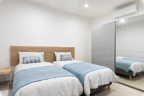 1 dormitorio con 2 camas con sábanas azules y blancas en Cosy apartment in Historic Fort Chambray, Gozo en Mġarr