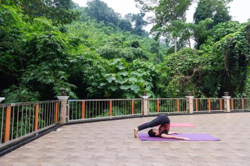 a woman doing a yoga pose on a mat at Namtok Sarika Resotel in Nakhon Nayok