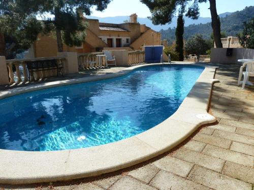 een groot zwembad met blauw water in een tuin bij Apartment mit Traumblick in Sóller