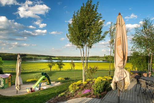 a patio with umbrellas and a playground with a slide at Penzion Blanský Les in Dubné