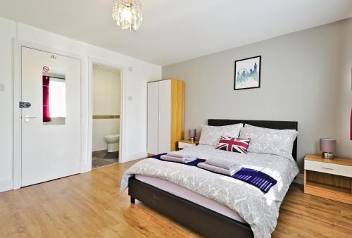 a bedroom with a king sized bed and a bathroom at Harlinger Lodge in London