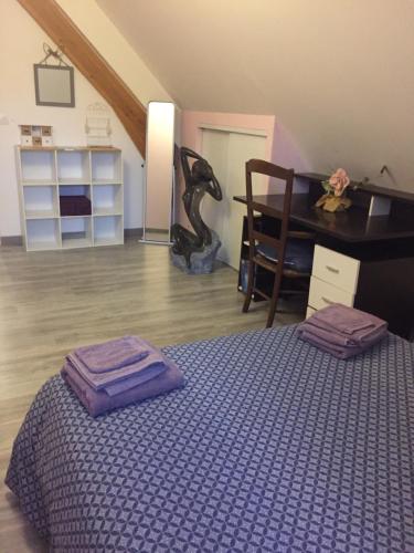 sypialnia z łóżkiem z fioletową pościelą i komodą w obiekcie L’escale du Bohain w mieście Nassandres