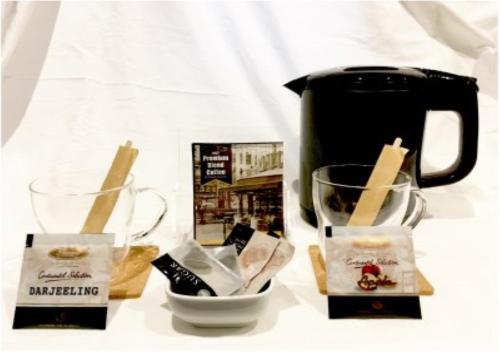 a tea pot and two cups on a table at Third Place Hotel in Saitama