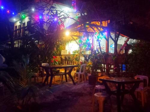 a patio with tables and chairs at night at Aquing's Place in El Nido