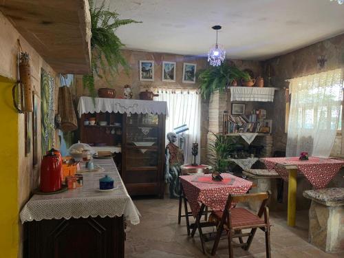 a kitchen with tables and chairs in a room at Pousada Paraíso São thome in São Thomé das Letras