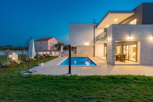 a house with a swimming pool in the backyard at Villa F&A ZadarVillas in Donje Raštane