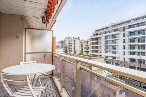 un balcon avec une table et des chaises blanches sur un immeuble dans l'établissement Le Cocon Juanais - Welkeys, à Antibes