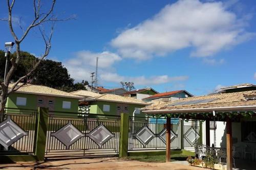 una valla verde frente a un grupo de casas en Hotel Vison en Jarinu