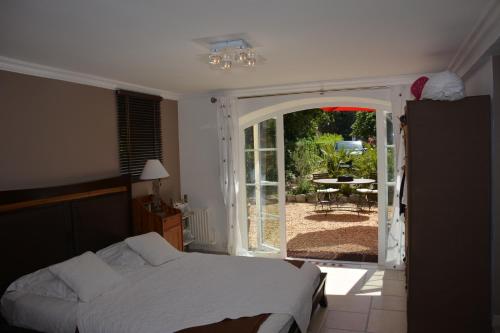 una camera con letto e una porta aperta su un patio di La Javanaise a Saint-Aygulf