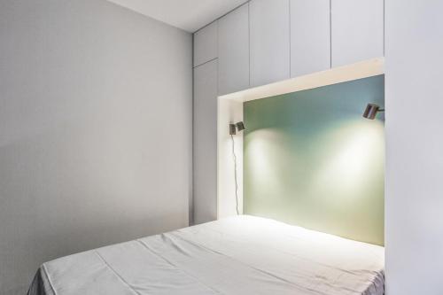 - une chambre avec un lit blanc et une tête de lit dans l'établissement Le Cocon Juanais - Welkeys, à Antibes