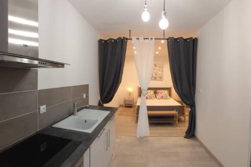 een badkamer met een wastafel en een kamer met een bed bij LES PRAIRIES DE L'ENCREME in Céreste