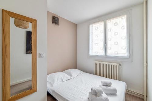 ein kleines Schlafzimmer mit einem Bett und einem Spiegel in der Unterkunft Modern and bright flat in Monplaisir district Lyon center - Welkeys in Lyon