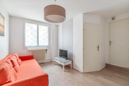 ein Wohnzimmer mit einem Sofa und einem TV in der Unterkunft Modern and bright flat in Monplaisir district Lyon center - Welkeys in Lyon