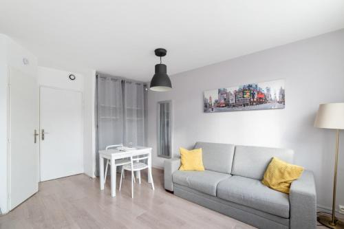 uma sala de estar com um sofá e uma mesa em Nice and modern studio in Monplaisir district in Lyon - Welkeys em Lyon