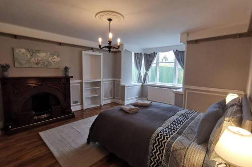 a bedroom with a large bed and a fireplace at Broomfield Cottage South Luss in Glasgow