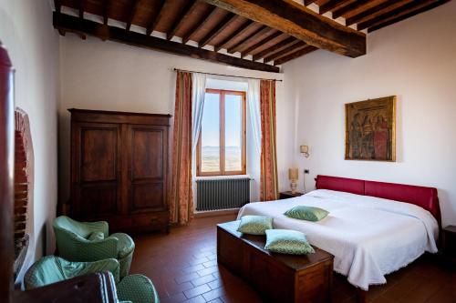 a bedroom with a bed and a window and chairs at Albergo Santa Chiara in Sarteano