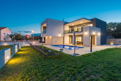 a house with a swimming pool in front of it at Villa F&A ZadarVillas in Donje Raštane