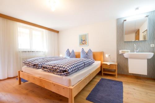 a bedroom with a bed and a sink in it at Landhaus Tröster in Ofterschwang