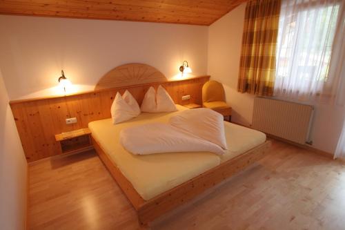 Schlafzimmer mit einem Bett mit weißer Bettwäsche und Kissen in der Unterkunft Appartement Top Tirol in Maurach