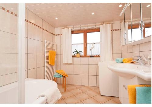 a bathroom with a tub and a sink and a shower at Landhaus Tröster in Ofterschwang