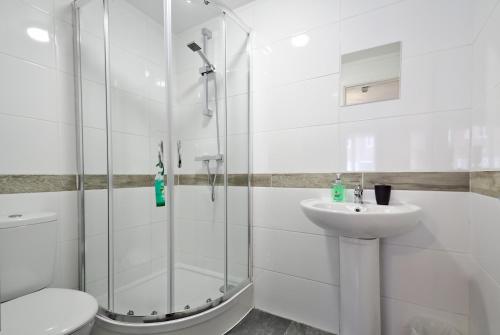 a bathroom with a shower and a toilet and a sink at Harlinger Lodge in London