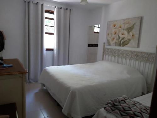 a white bedroom with a bed and a window at SÍTIO FLOR DE LYS in Jarinu