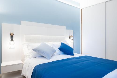a bedroom with a blue and white bed with pillows at Torri & Portici in Bologna
