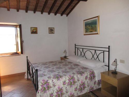 Schlafzimmer mit einem Bett und einem Fenster in der Unterkunft Agriturismo Podere Cappella in San Gimignano