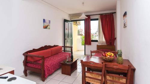 a living room with a red couch and a table at Ariadni Palace in Hersonissos