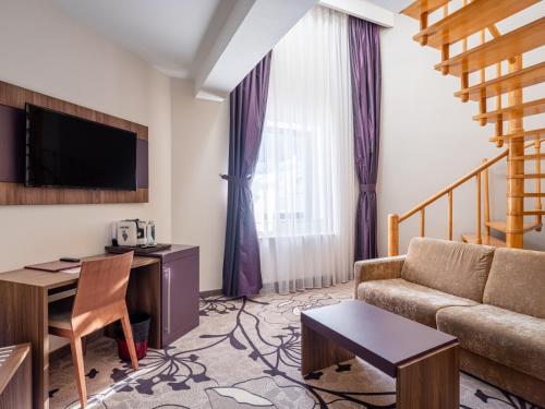 a living room with a couch and a desk at Hotel Miruna - New Belvedere in Poiana Brasov