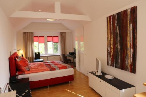 a bedroom with a bed and a desk with a computer at Villa Greve - Deluxe Suite in Bad Salzuflen