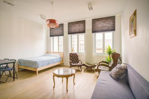 a living room with a couch and a bed at The Bright Stone Lodge. Heart of Antwerp in Antwerp