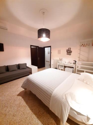 サレルノにあるB&B Portaroteseのベッドルーム(大きな白いベッド1台、ソファ付)